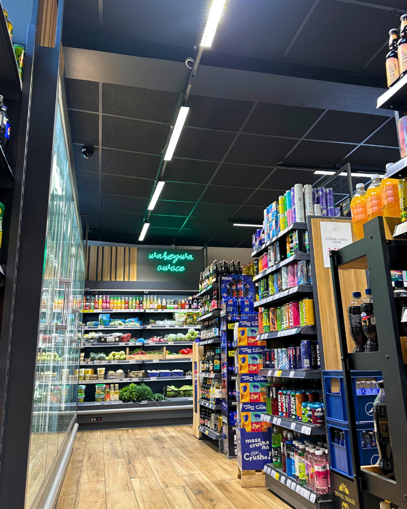 Oświetlenie alejek sklepowych z liniowymi oprawami nad regałami z produktami